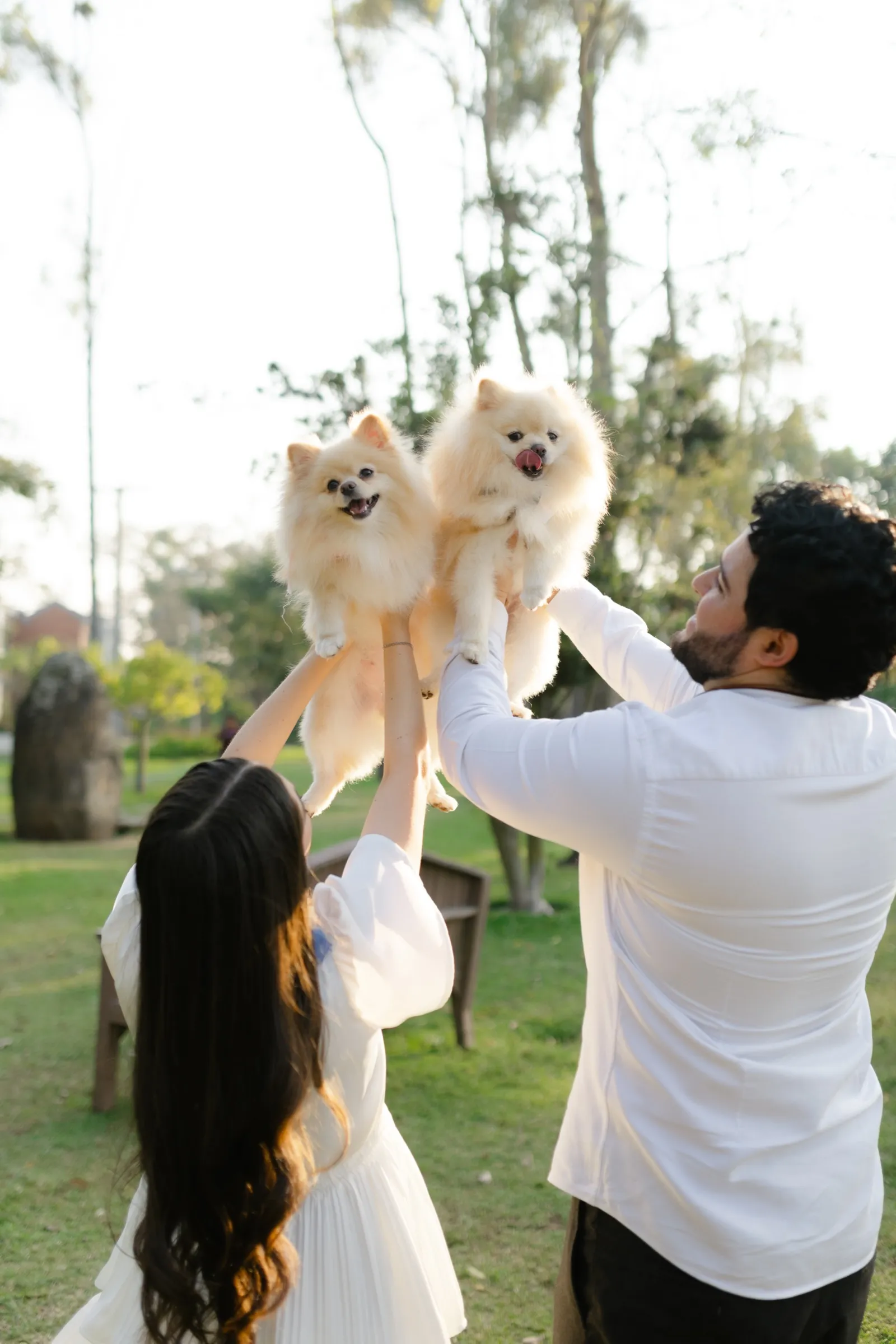 Josué levanta a su perro esponjoso mientras Katherine sonríe